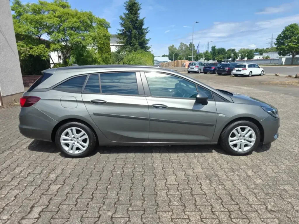 Opel Astra Edition Start/Stop Winterpaket 1.Hd Navi, grauer Kombi von der Seite, sichtbare Felgen und Seitenspiegel