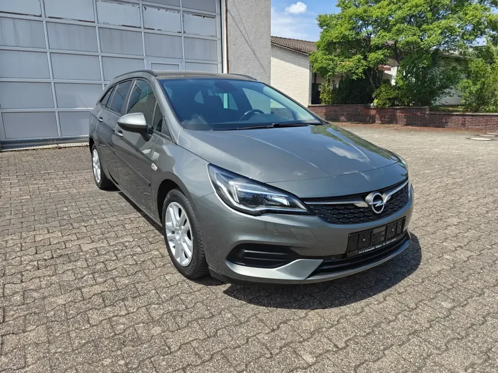 Opel Astra Edition Start/Stop Winterpaket 1.Hd Navi, grauer Kombi von vorne rechts, sichtbare Scheinwerfer und Felgen