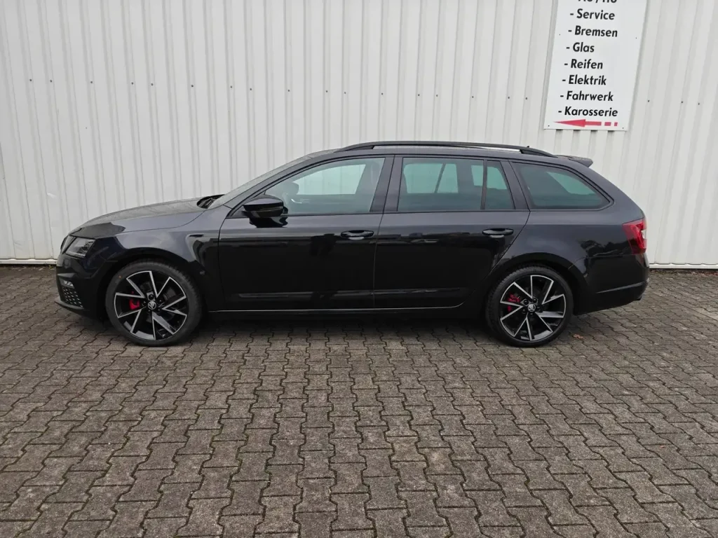 Skoda Octavia RS 8 fach Klima ZV PDC Kamera Navi eHK schwarzer Kombi Seitenansicht mit schwarzen Felgen und roten Bremssätteln.