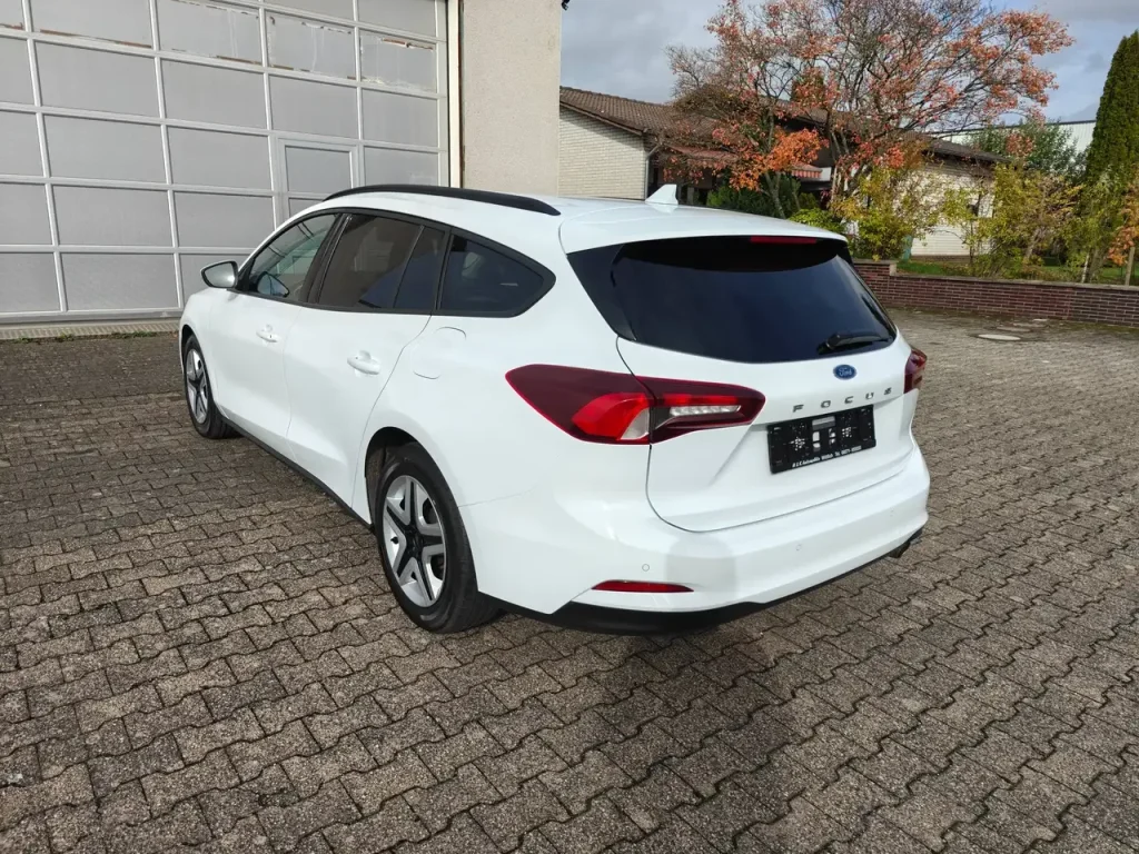 Ford Focus Cool Klima LED Shz PDC Airplay Winterpaket, weißer Kombi von hinten rechts, getönte Heckscheibe, Dachreling, LED-Rückleuchten, Alufelgen.