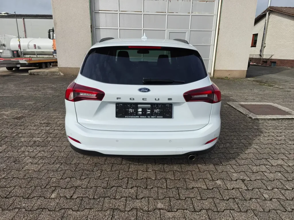 Heckansicht weißer Ford Focus Cool Klima LED Shz PDC Airplay Winterpaket mit getönten Scheiben und Einzelrohr-Auspuff.