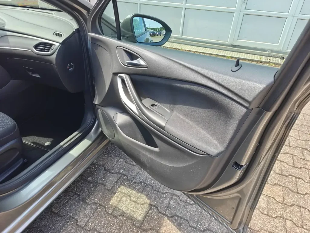 Opel Astra Edition Start/Stop Winterpaket 1.Hd Navi Fahrertür mit Türverkleidung, Fensterheberschalter und Türgriff, teilweise Armaturenbrett und Sitz sichtbar