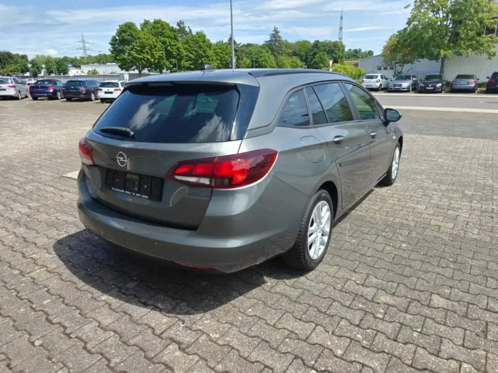 Opel Astra Edition Start/Stop Winterpaket 1.Hd Navi Kombi in Grau von hinten rechts, mit getönten Heckscheiben und Rückleuchten.