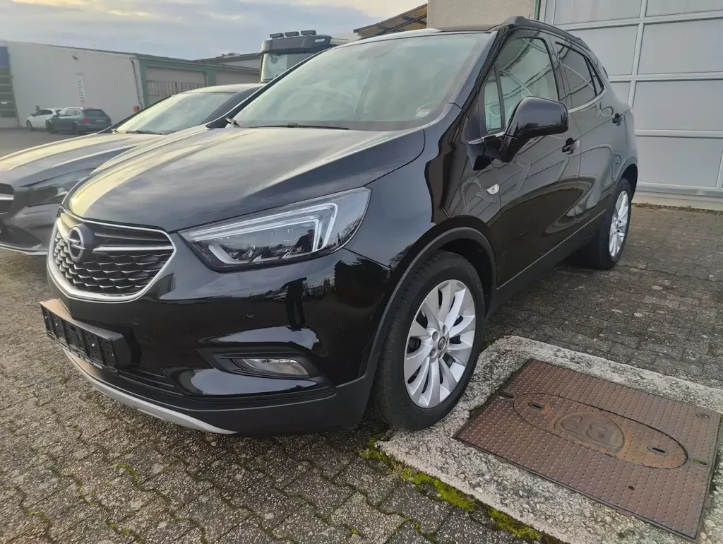 Opel Mokka X Innovation Start/Stop in Schwarz, Front- und Seitenansicht, mit markantem Kühlergrill und LED-Scheinwerfern, geparkter Zustand.