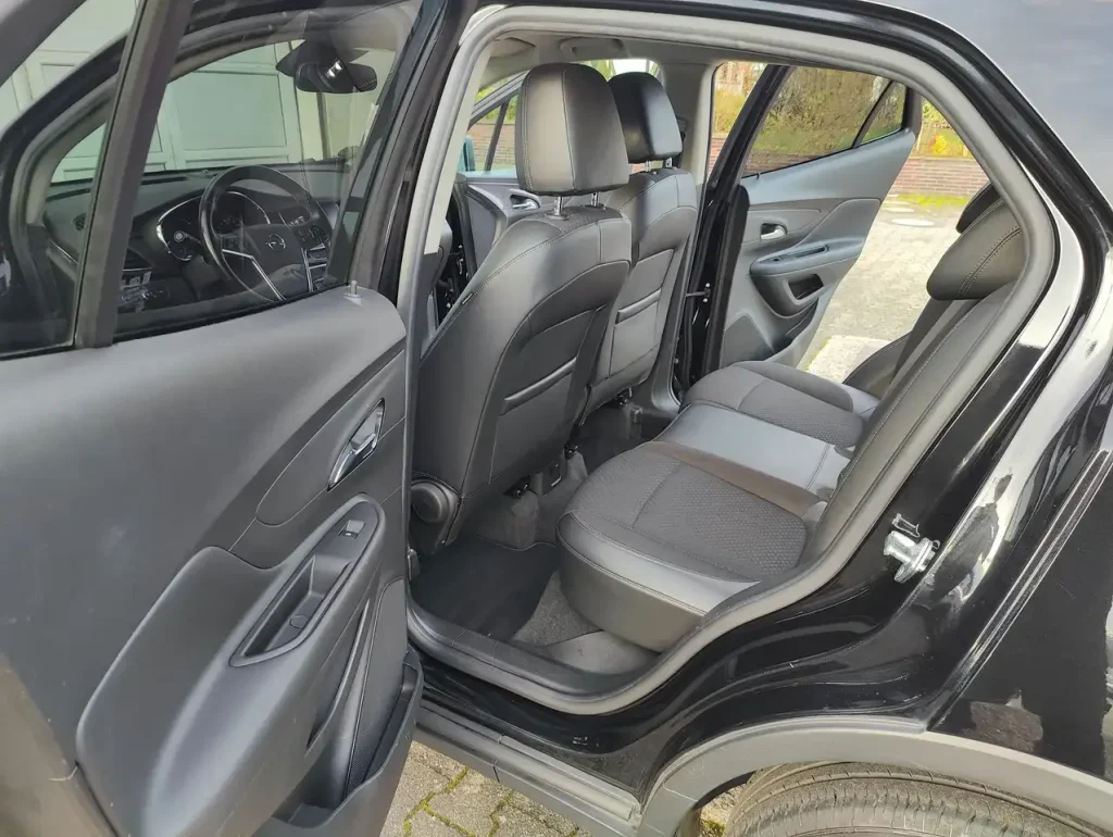 Opel Mokka X Innovation Start/Stop, geöffnete hintere Tür, Blick auf Rücksitze und Vordersitze mit schwarzer Polsterung.
