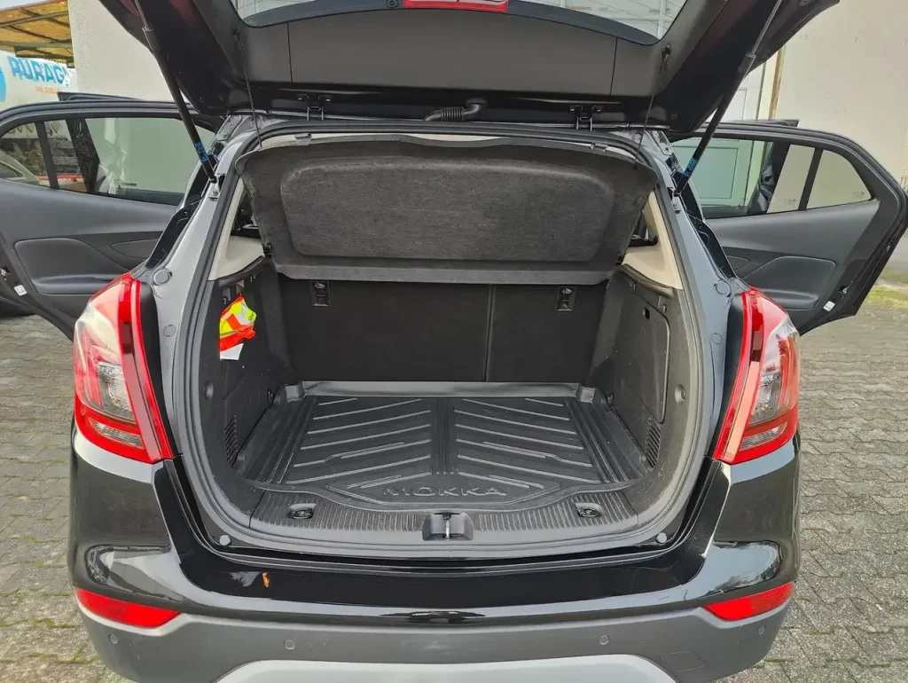 Kofferraum mit geöffneter Heckklappe und geöffneten hinteren Türen des schwarzen Opel Mokka X Innovation Start/Stop.
