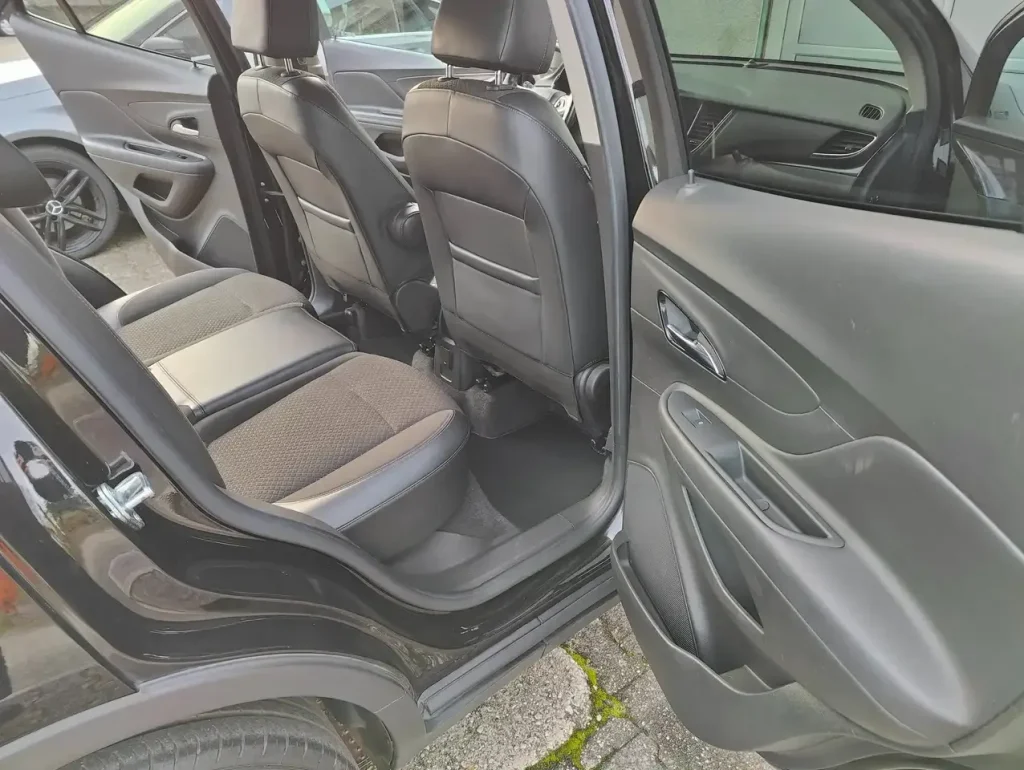 Opel Mokka X Innovation Start/Stop, geöffnete hintere rechte Tür, Blick auf Rücksitze und Türverkleidung, Sitzbezüge aus Stoff und Leder.