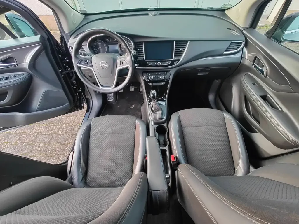 Innenraum mit Armaturenbrett, Lenkrad, Mittelkonsole und Vordersitzen des Opel Mokka X Innovation Start/Stop.