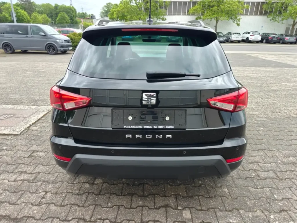 Heckansicht des schwarzen SEAT Arona Style mit sichtbaren Rückleuchten und Dachreling.