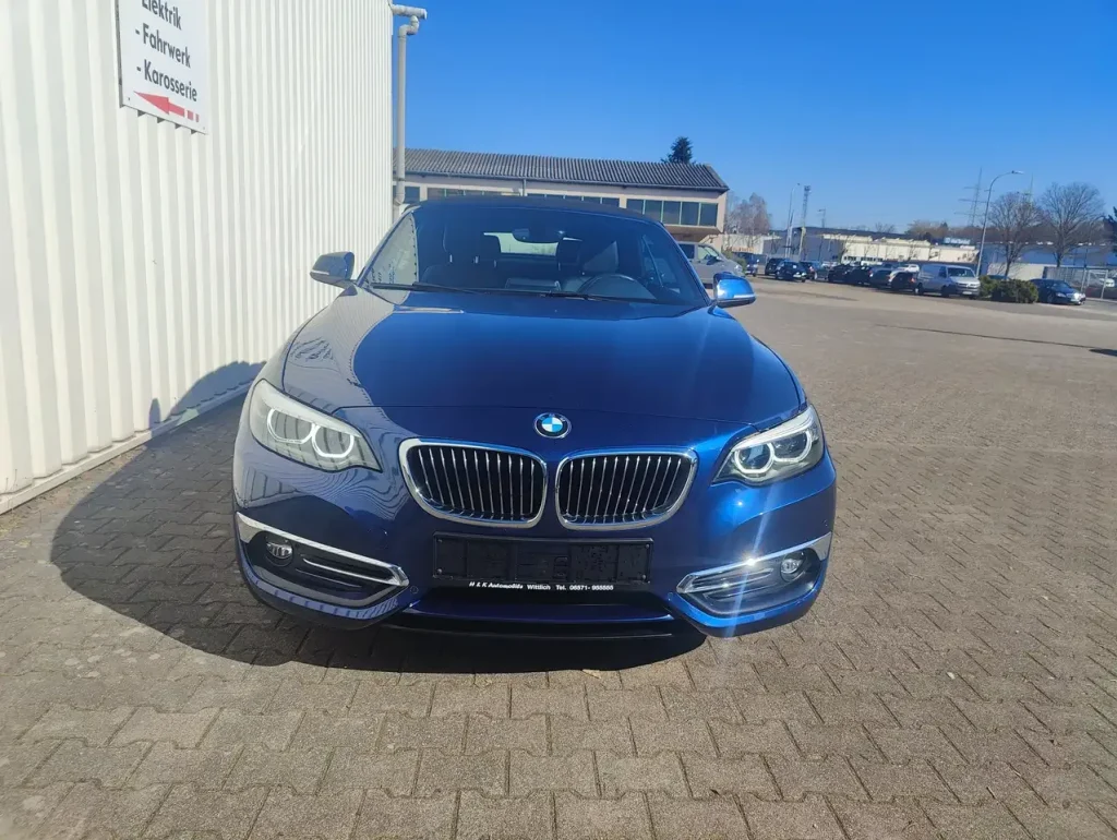 BMW 218 218 i Luxury Line LED Leder Alu Shz PDC, blaue Frontansicht mit LED-Scheinwerfern und Kühlergrill