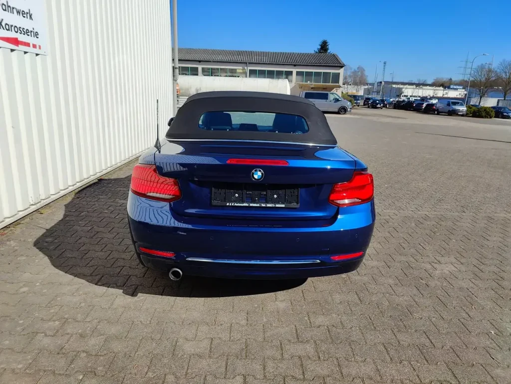 BMW 218 218 i Luxury Line LED Leder Alu Shz PDC Cabrio von hinten mit geschlossenem Verdeck in Blau