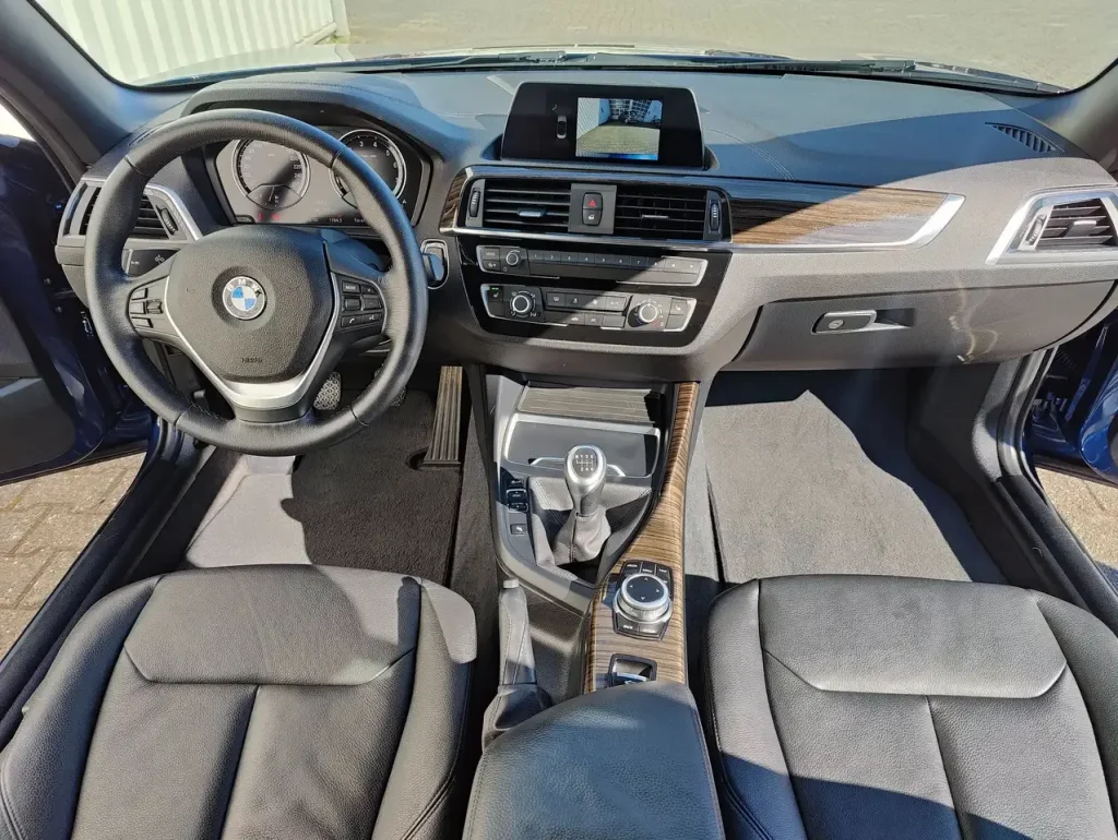 Innenraum mit Lenkrad, Mittelkonsole mit Schaltknüppel und Infotainment-Display des BMW 218 218 i Luxury Line LED Leder Alu Shz PDC